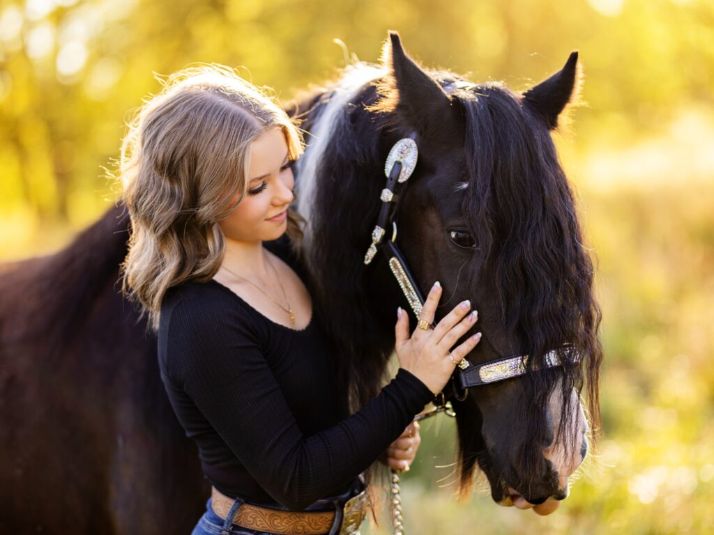 Equestrian horse photos in a country setting with grass and a barn with a high school senior for their senior portraits