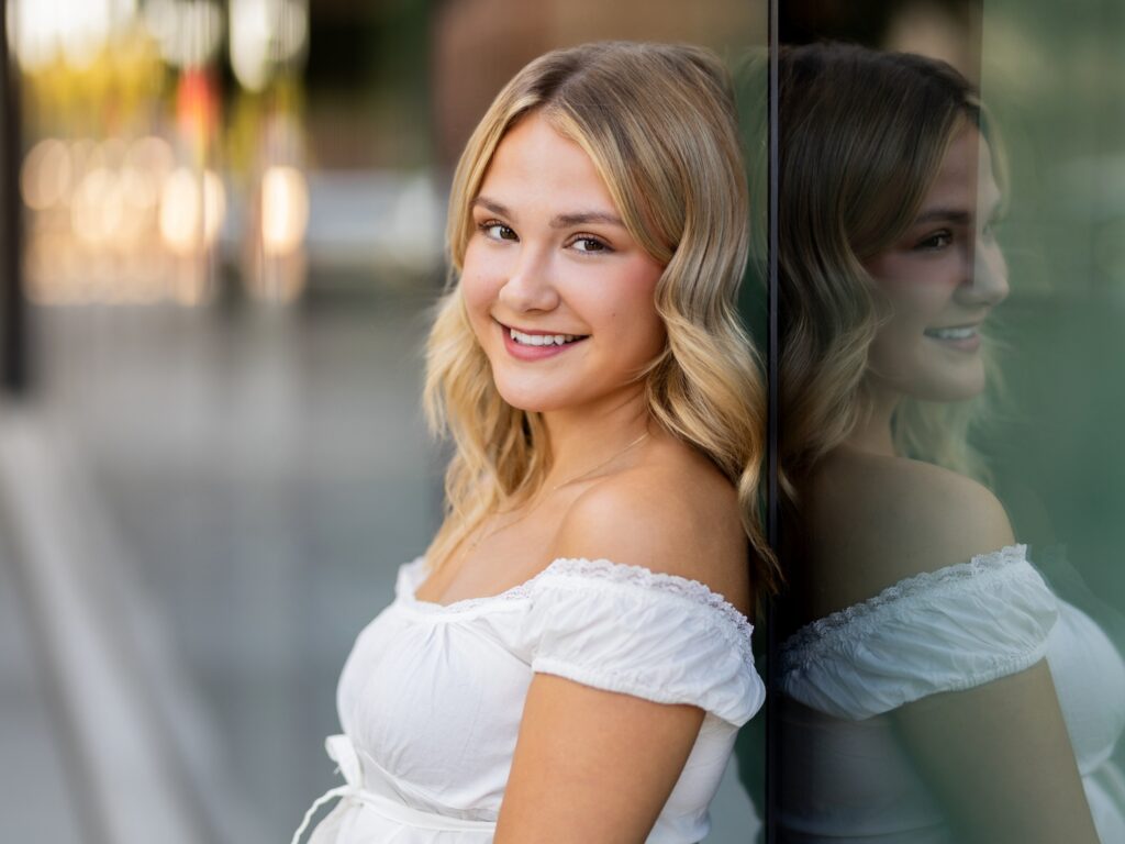 Girl senior photos in Vancouver Washington Lake Oswego, West Linn Oregon and Portland Oregon in the summer in an urban setting in downtown leaning against glass windows