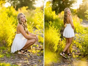 Girl senior photos in Vancouver, WA wearing a white halter dress and black platform sandals while posing among sunlit greenery near the river.